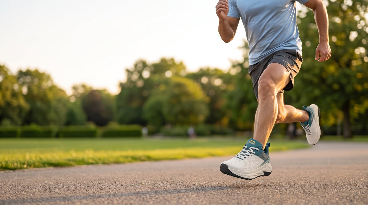 A man running on a park path in white Slazenger running shoes with teal panels
